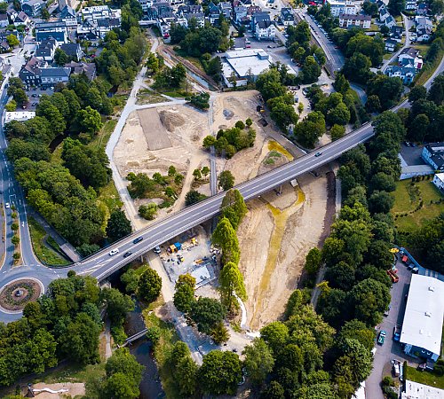 Die Baustelle des Wiehlparks Ende Juli 2022: Links unterhalb der Brücke ist die Bodenplatte fürs Seecafé zu sehen. Gut zu erkennen ist das Netz der Hauptwege sowie am oberen Rand der mit Wasser gefüllte Teil des Zulaufs in den See. Foto: Stadt Wiehl Die Baustelle des Wiehlparks Ende Juli 2022: Links unterhalb der Brücke ist die Bodenplatte fürs Seecafé zu sehen. Gut zu erkennen ist das Netz der Hauptwege sowie am oberen Rand der mit Wasser gefüllte Teil des Zulaufs in den See. Foto: Stadt Wiehl