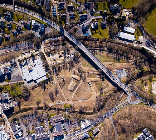 Die Drohnenaufnahme zeigt den Stand der Bauarbeiten am Wiehlpark im März 2022. Rechts oberhalb vom Kreisverkehr ist eine helle Schotterfläche zu erkennen: der künftige Standort des Seecafés. Foto: Stadt Wiehl